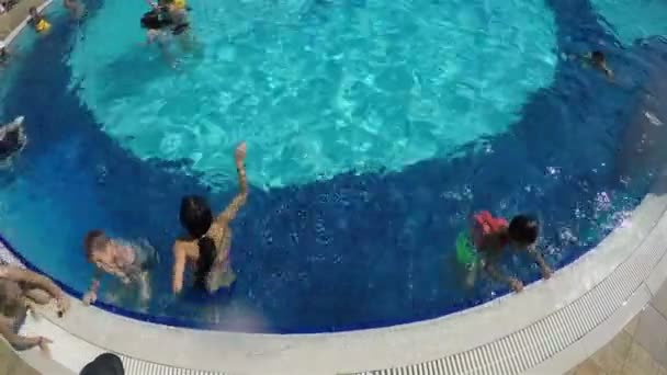 Niños se bañan en agua clara en la piscina en un día caluroso — Vídeos de Stock