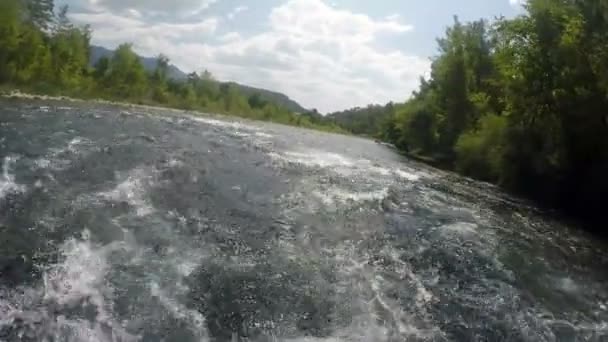 Течение горной реки переворачивает лодку с туристами между скалами — стоковое видео