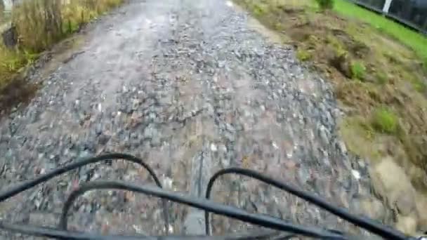 Een fietser rijdt over een stenen weg — Stockvideo