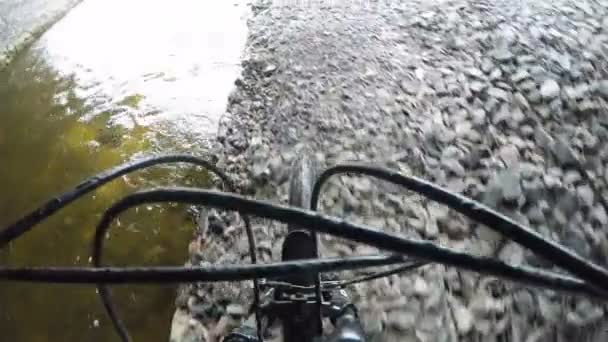 un athlète roule un vélo le long du ruisseau sous le pont 