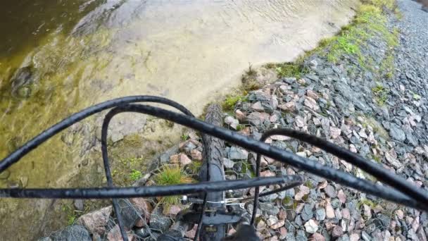 La Bicicletta poggia sulla sponda in pietra del torrente coperta da una rete — Video Stock