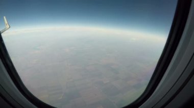 Uçağın kanadı altındaki tarlalar ve dilimlenmiş alanlar.