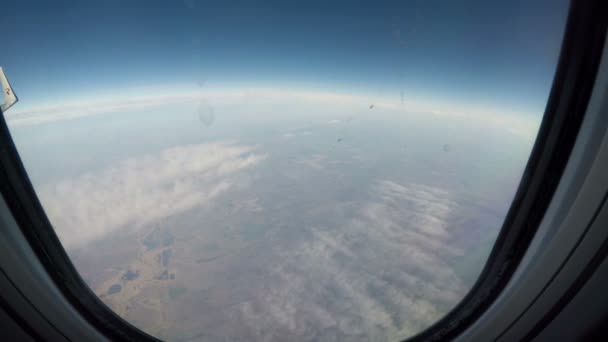 À une altitude de 10 000 mètres, la terre est visible sous des nuages flottants — Video