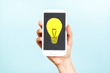 El bir telefon genel kavram bir ampul ile mavi arka plan üzerinde gösterilen