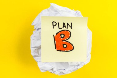 Plan B message on paper ball and yellow background clipart