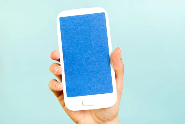 Ręka Wyświetlone Niebieski Ekran Pionowy Papieru Mobilnych Koncepcji Niebieskim Tle — Zdjęcie stockowe
