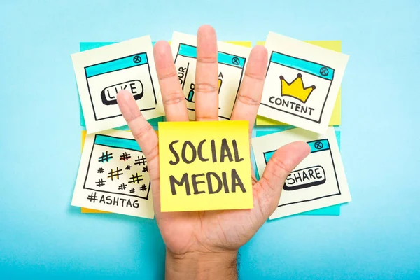 Szociális média a kezét a kék háttér — Stock Fotó