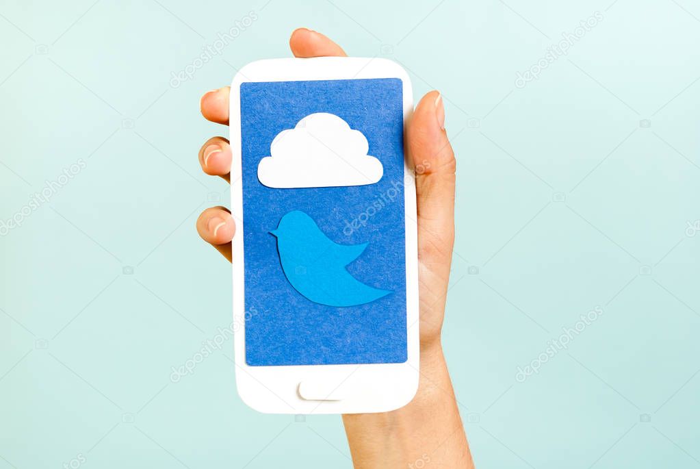 Conceptual phone showing a cloud and bird on blue background