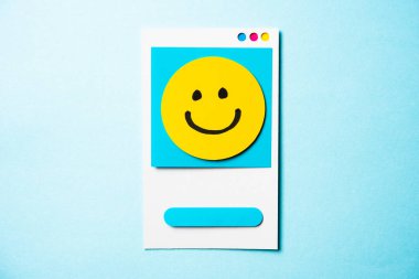 Note with happy face and paper smart phone concept on blue backg
