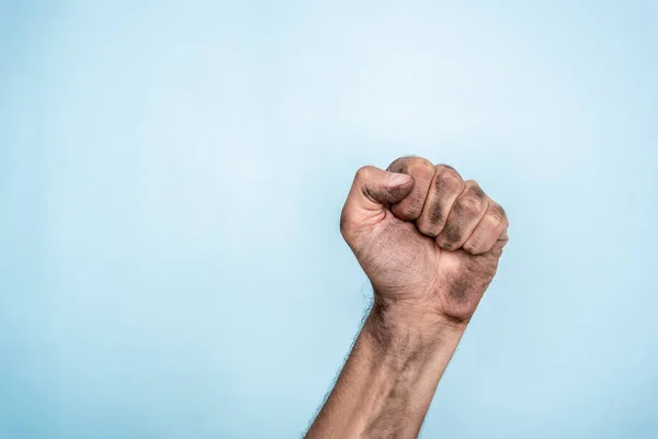 Male dirty fist hand on blue background — Stockfoto