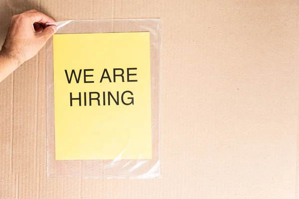 We are hiring text on yellow paper sheet on transparent bag and