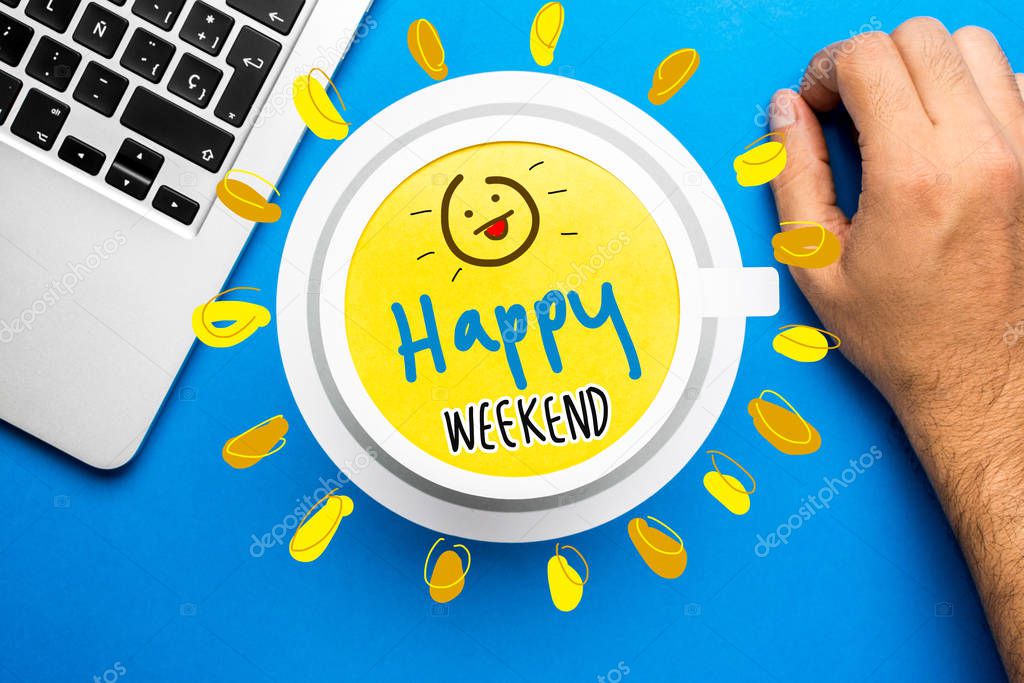 Happy weekend quote and coffee cup on blue background with lapto