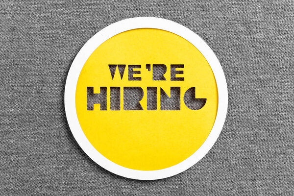 Letters cut on yellow paper with the message "We are hiring" on 