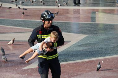 Firefighter holding a child during protest against terrorism clipart