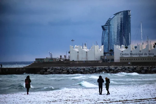 Barcelona, İspanya - 8 Şubat 2018: Barcelona beach karda zevk insanlar. Seyrek bir meteorolojik olay kar İspanyol deniz kenarı vardır.