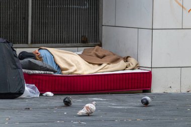 Barselona, İspanya. 7 Nisan 2020. Barceloneta metro istasyonunun yakınındaki sokakta uyuyan evsiz bir kadın.
