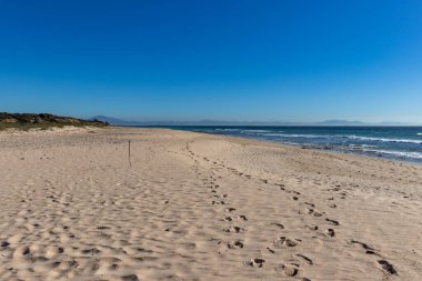 Akdeniz 'in Atlantik' le buluştuğu ve arkasında Afrika dağlarının olduğu Tarifa yakınlarındaki boş Bolonya plajı.