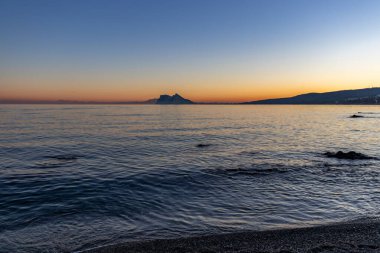 İspanya 'da Alcaidesa sahilinden gün batımında Cebelitarık Kayası görüldü