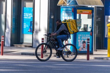 Barselona, İspanya. 24 Nisan 2020 'de. Glovo teslimatçısı alarm durumunda Barcelona 'nın boş sokaklarında bisiklet sürüyor.
