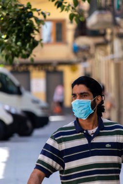 Barselona, İspanya. 29 Nisan 2020 'de. Koronavirüs tecridi sırasında sokakta koruyucu maske takan bir adam.