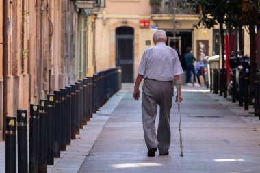 Barselona, İspanya. 4 Mayıs 2020. Barselona 'nın merkezinde kıdemli bir adam yaşlıların dışarı çıkmasına izin verilen saatlerde yürüyor.