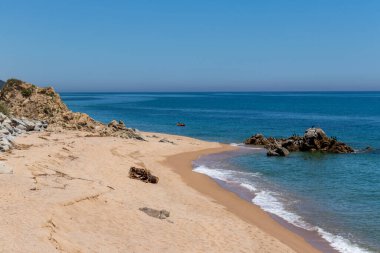 Barselona, İspanya. 20 Mayıs 2020. Kapalı kapılar ardında Maresme bölgesindeki boş bir Sant Pol de Mar plajında kano süren insanlar
