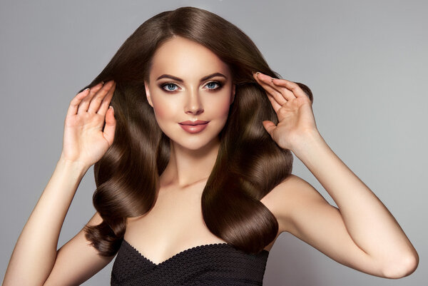 Девушка с длинными и блестящими волнистыми волосами
 .