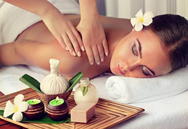 Spa salonunda masaj yaptıran bir kadın.
