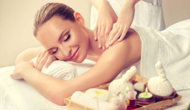Spa salonunda masaj yaptıran bir kadın.