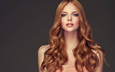 Kızıl saçlı kız uzun ve parlak kıvırcık saçlı. Güzel model kadın kıvırcık saç modeli ile. Bakım ve güzellik saç