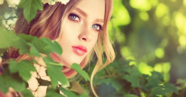 Güzel bahar modeli kız yaz çiçeği parkta güzel kokulu çiçekler. Kadın bir çiçek bahçesinde. Moda, kozmetik ve parfümler. Kıvırcık sarı saçlı