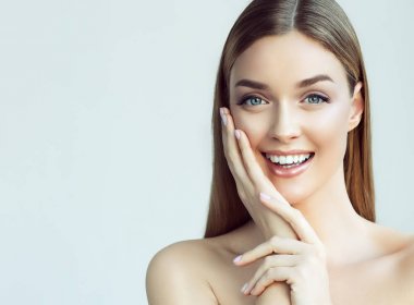 Mutlu güzel kız yanakları ile bir kahkaha görünümlü stright tutuyor. Etkileyici yüz ifadeleri. Kozmetik ve Spa, cilt bakım modeli