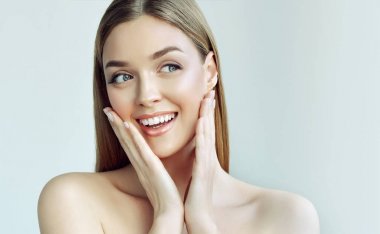 Mutlu güzel kız tarafına bakarak bir kahkaha ile yanaklarının tutarak. Etkileyici yüz ifadeleri. Kozmetik ve Spa, cilt bakım modeli