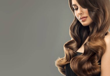 Uzun ve parlak kıvırcık saçlı esmer kahverengi kız. Güzel model kadın kıvırcık saç modeli ile. Bakım, kozmetik ve güzellik