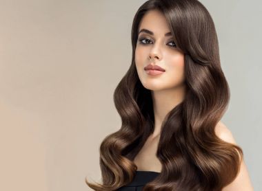 Uzun ve parlak kıvırcık saçlı esmer kahverengi kız. Güzel model kadın kıvırcık saç modeli ile. Bakım, kozmetik ve güzellik