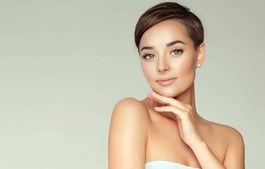 Beautiful Young Woman with Clean Fresh Skin. Face care . Facial treatment . Cosmetology , beauty and spa . Girl with short hair. clipart