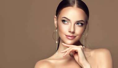 Güzel kız. Modayı takip eden büyük küpeli şık ve şık bir kadın. Moda görünüşü, güzellik ve tarz. Doğal makyaj & kolay biçim verme