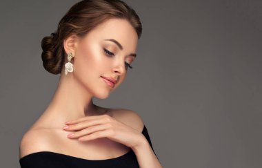 Güzel kız. Modayı takip eden büyük küpeli şık ve şık bir kadın. Moda görünüşü, güzellik ve tarz. Doğal makyaj & kolay biçim verme