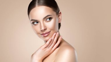 Temiz tenli güzel genç bir kadın yüzüne dokunuyor. Kız yüz tedavisi. Kozmetik, güzellik ve kaplıca. Kadın model, bakım konsepti