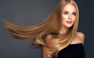 Parlak ve düz uzun saçlı güzel bir model kadın. Keratin düzleştiriyor. Tedavi, bakım ve spa prosedürleri. Sarışın güzel kız pürüzsüz saç stili