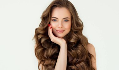 Uzun kıvırcık saçlı güzel esmer model kız. Gülümseyen kadın saç stili dalgalı bukleler. Kırmızı tırnaklı manikür. Moda, güzellik ve makyaj portresi