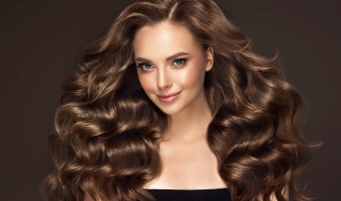 Uzun dalgalı ve parlak saçlı güzel bir manken kız. Kıvırcık saçlı esmer kadın.