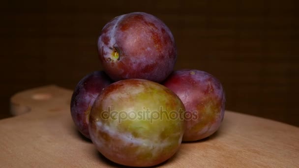 Portion of Plums at Wood Rotating plate — Stock Video