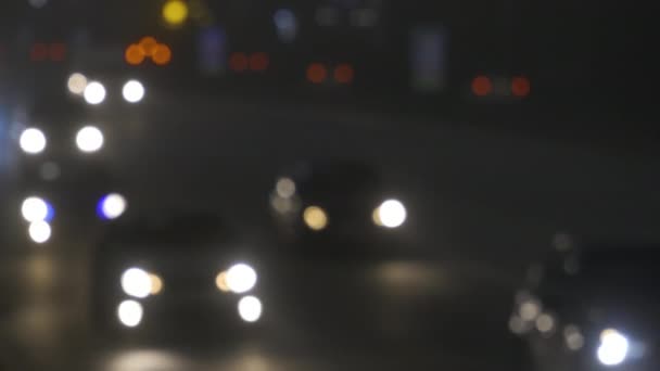 Luces de tráfico desenfocadas de la ciudad nocturna. Color Bokeh borroso de transporte en movimiento y ruido típico de la ciudad . — Vídeos de Stock