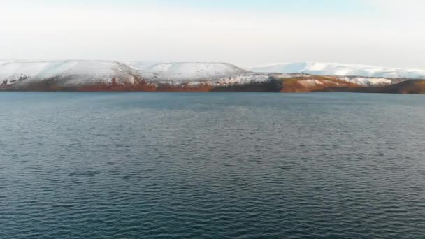 Flug über Ozean, offene See. Dynamische Luftaufnahme des Berges mit Schnee. — Stockvideo