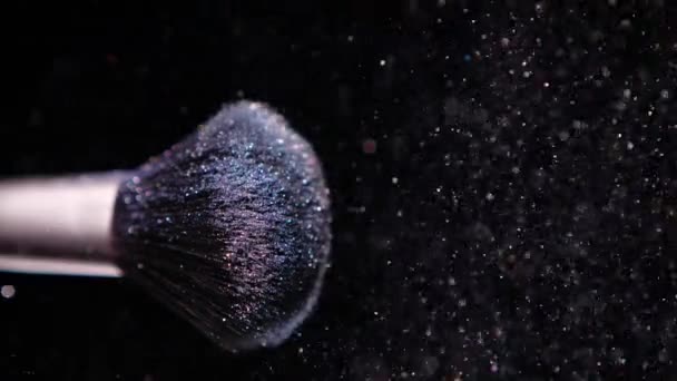 Maquillaje cepillo con polvo azul de color en el fondo negro Slow Motion — Vídeos de Stock