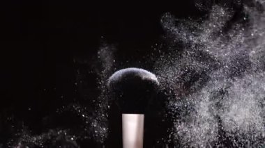 Siyah arkaplan Yavaş Harekette renkli beyaz toz ile makyaj fırçası