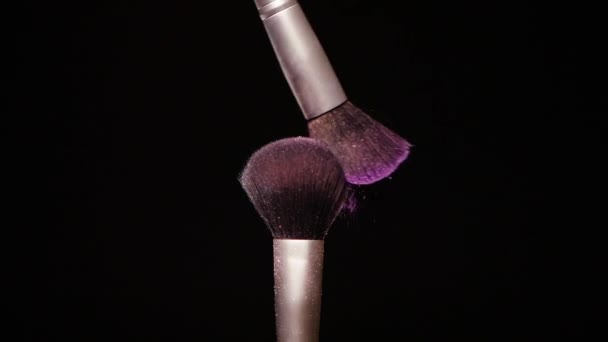 Make up brush with colored purple powderon at black background Slow Motion — Stock Video
