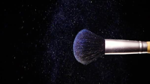 Make up brush with colored blue powderon at black background Slow Motion — Stock Video