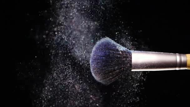 Maquillaje cepillo con polvo azul de color en el fondo negro Slow Motion — Vídeos de Stock